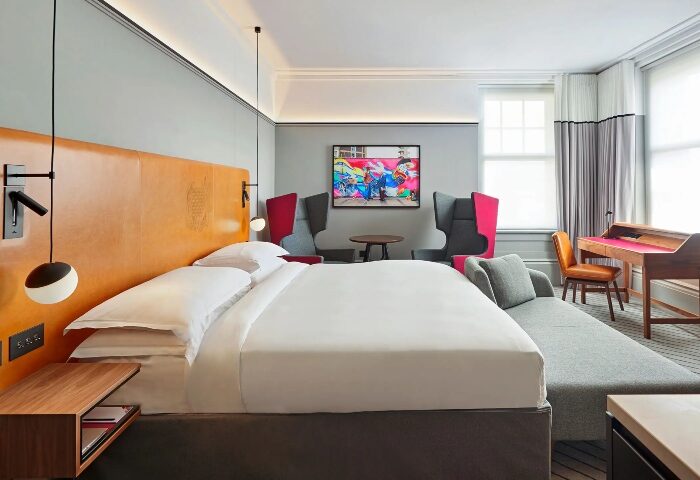 Andaz London Liverpool Street hotel room. Cool, trendy design by Hyatt in Shoreditch. King bed, desk, colorful art. Gay travel advice.