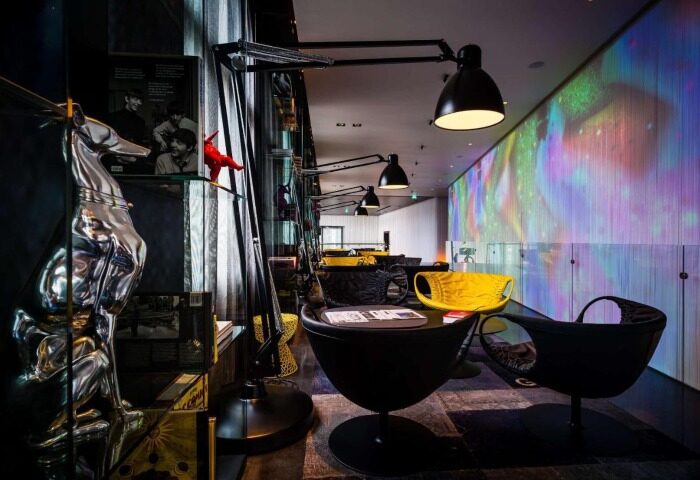 art'otel Amsterdam lobby with modern design, colorful wall art, stylish chairs, and unique art pieces. Coolest art hotel near gay area.