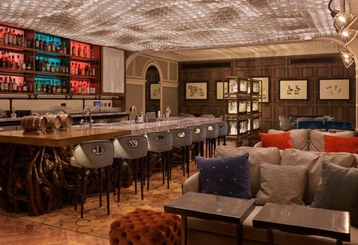 Coolest cocktail bar at Great Scotland Yard Hotel, Soho, London. Gay travel advice: stylish interior, bar stools, and colorful liquor display.