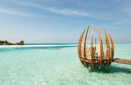 LUX* South Ari Atoll: Coolest gay beach bar in Maldives. Overwater structure with seating, turquoise water, and blue sky. Gay travel.