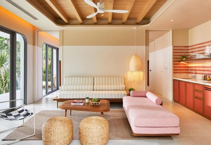 The Standard Hua Hin hotel suite. Coolest gay honeymoon hotel with stylish pink chaise lounge, striped couch, and kitchenette. Beach views.