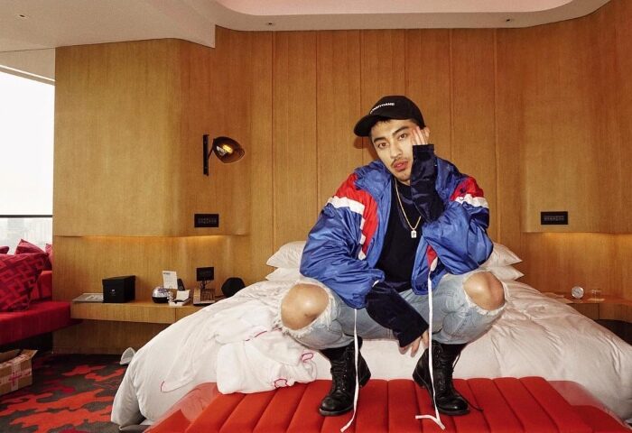 Gay traveler at W Shanghai - The Bund, a cool hotel on the river. Man in ripped jeans and jacket poses in stylish room. Gay travel advice.