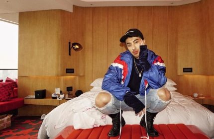 Gay traveler at W Shanghai - The Bund, a cool hotel on the river. Man in ripped jeans and jacket poses in stylish room. Gay travel advice.