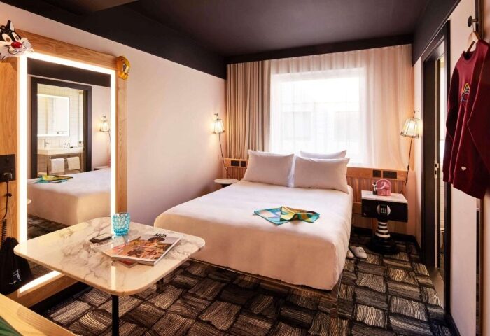 Mama Shelter London hotel room. Coolest Shoreditch hotel with double bed, cartoon decor, and a quirky design. Gay travel lodging.