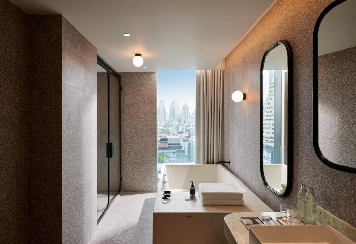 Bathroom at The Standard, Bangkok Mahanakhon. Modern design, bathtub with city view. Cool gay hotel for travel advice.
