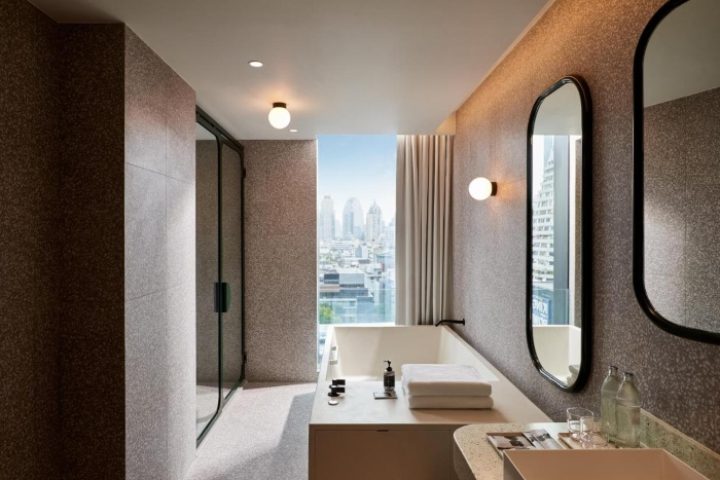 Bathroom at The Standard, Bangkok Mahanakhon. Modern design, bathtub with city view. Cool gay hotel for travel advice.