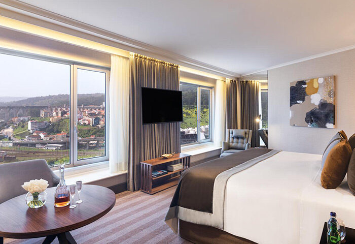 Corinthia Hotel Lisbon room with city view. Luxury gay hotel in city center. Modern design, comfortable bed, and large windows. Perfect for gay travel.