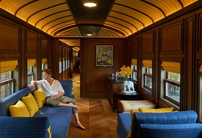 Gay man in InterContinental Khao Yai Resort's train-themed suite. Crazy design, luxury travel. Khao Yai hotel, Thailand.