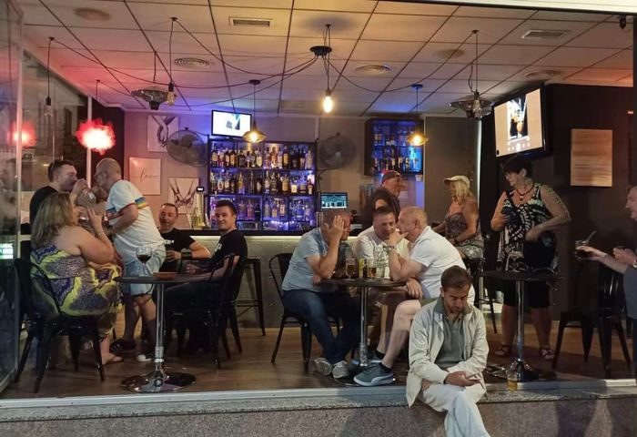 People at DD's s Bar, a gay bar in Benidorm, Spain, enjoying drinks. Interior view. Gay travel advice. Nightlife scene.