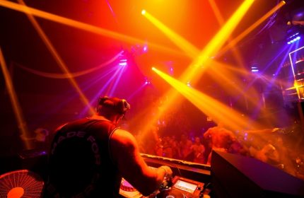 Industry gay bar: DJ under lights, crowd dancing. Gay men's travel advice. DSC07645. Nightlife, music, entertainment.