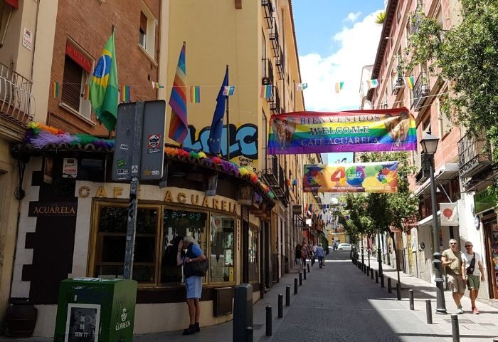 Madrid's gay bar street scene: Cafe Aquarela, a mystic gay bar, is adorned with rainbow flags and welcomes visitors. A vibrant gay travel destination.