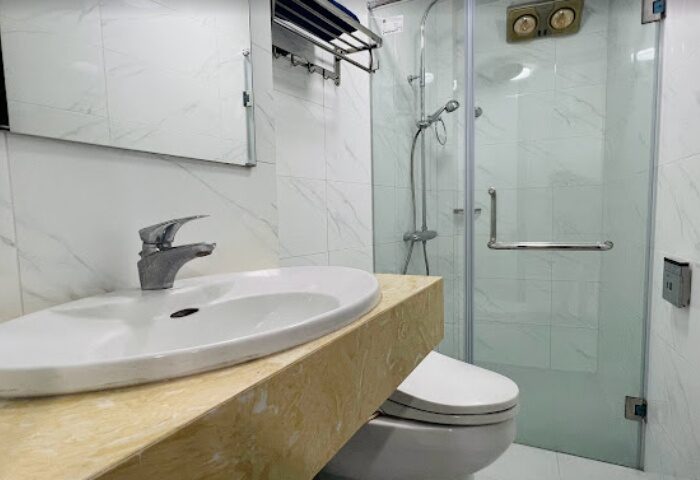 DaNi Spa Hanoi bathroom. Clean, modern design with white marble tiles, glass shower, and sleek fixtures. Gay travel advice for Hanoi, Vietnam.