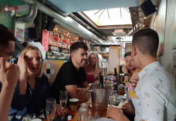 Dalston Superstore gay bar: A group of friends at a table, drinking champagne. Popular gay venue in London's Dalston area.