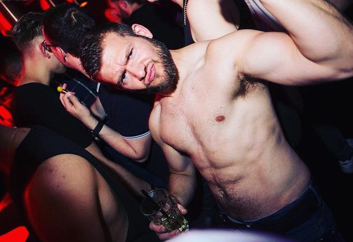 Delicious Frankfurt: Shirtless bearded man at a gay club. Gay travel advice, nightlife scene. Party, drinks, and fun.