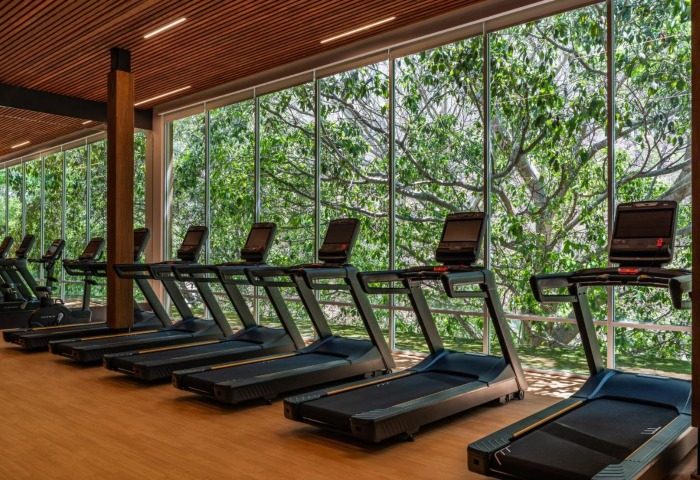 Gym at Delta Hotels by Marriott Riviera Nayarit All-Inclusive. Treadmills face a window with nature views. Ideal for gay men's travel fitness.