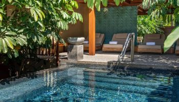 Delta Hotels by Marriott Riviera Nayarit All-Inclusive pool view. Relaxing gay travel destination with lounge chairs and lush greenery.