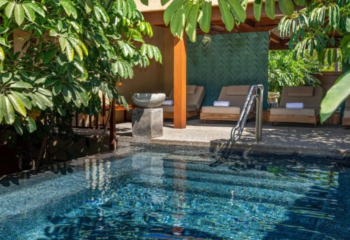 Delta Hotels by Marriott Riviera Nayarit All-Inclusive pool view. Relaxing gay travel destination with lounge chairs and lush greenery.