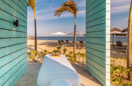 Delta Hotels Riviera Nayarit All-Inclusive: Massage table with beach view. Gay travel to Mexico for relaxation and pampering. Palm trees, sand.