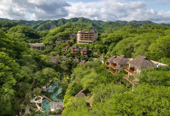 Delta Hotels by Marriott Riviera Nayarit All-Inclusive resort. Lush jungle setting with pools and thatched-roof buildings. Gay travel destination.