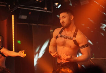 Destination Bar: Muscular Asian man in harness at a gay bar. Nightlife, travel, and gay destination advice. Leather.