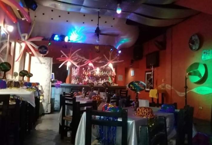 Diva's Gay Bar in Puerto Vallarta. Interior view of the bar with tables, chairs, decorations, and a bar in the background. Nightlife.