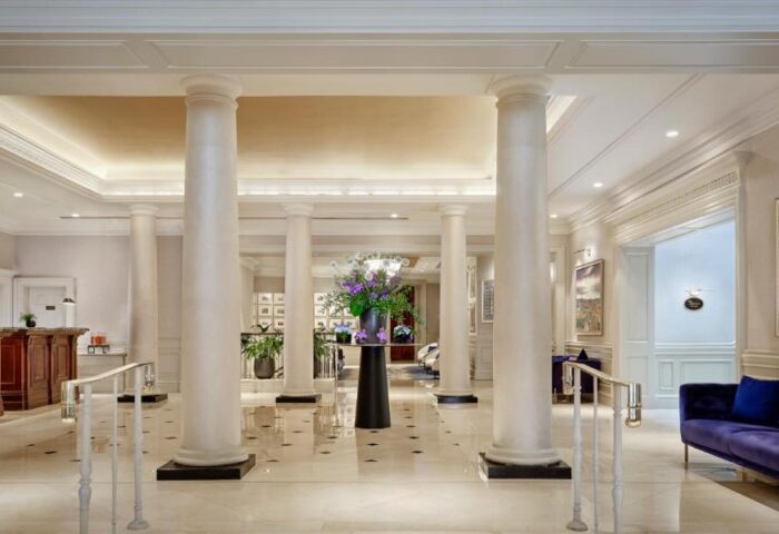 Lobby of The College Green Dublin Hotel, a gay-friendly luxury hotel. Interior with columns, seating, and floral arrangement. Dublin hotel.