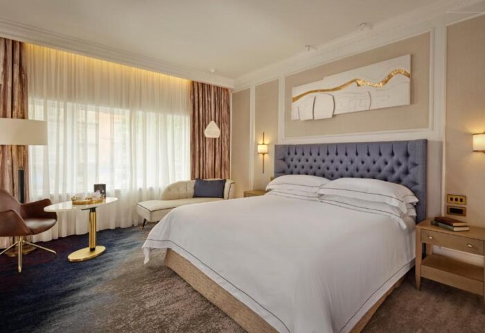 Dublin luxury hotel room at The College Green Hotel, Autograph Collection. Gay-friendly hotel with a king bed, chair, and modern decor.