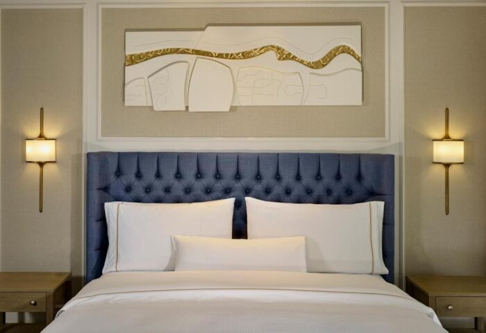 Dublin gay-friendly luxury hotel room at The College Green Hotel, Autograph Collection. Blue headboard, white linens, modern art.