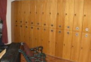 Lockers at E15 Club, a gay sauna. Wooden lockers line the wall, offering secure storage. Seating area visible. Gay travel advice.