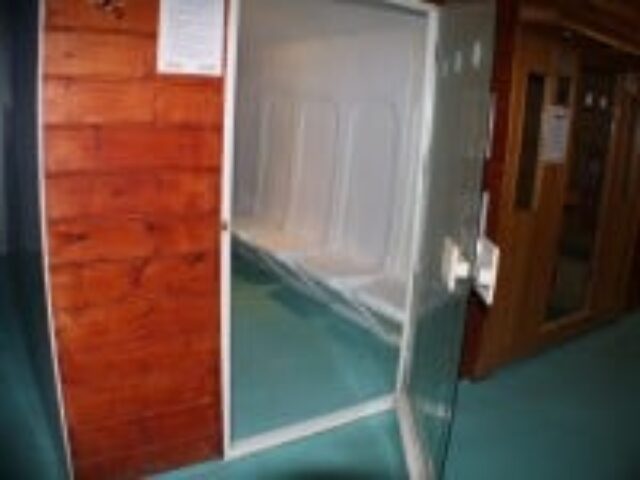 E15 Club gay sauna interior. White tiled sauna room with bench seating. Part of a gay travel guide to saunas and clubs.