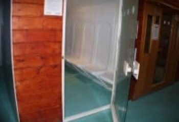 E15 Club gay sauna interior. White tiled sauna room with bench seating. Part of a gay travel guide to saunas and clubs.