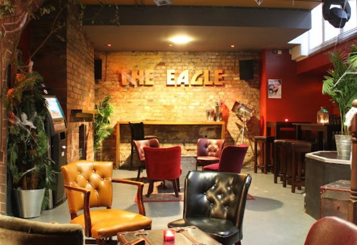 Interior of The Eagle Manchester, a gay bar. Exposed brick, leather chairs, and a relaxed atmosphere for gay men's travel.