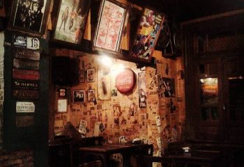 El Almacen Gay Bar interior in Mexico. Walls covered in posters, photos, and memorabilia. Cozy, dimly lit atmosphere. Gay travel destination.