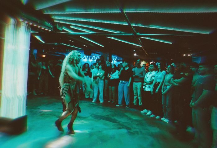 Drag queen performing at El Convento Rico Night Club in Toronto. Gay nightlife scene with a crowd watching the show. Gay travel advice.
