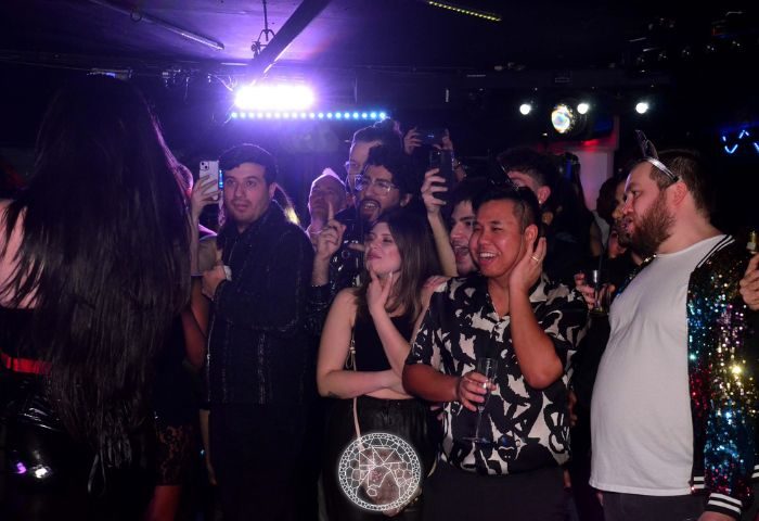 Crowd at El Convento Rico Night Club in Toronto. Gay men enjoying the show, taking photos. Popular gay bar, vibrant nightlife.