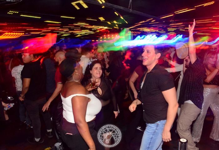 El Convento Rico Night Club in Toronto: People dancing under colorful lights. Gay nightlife travel destination.