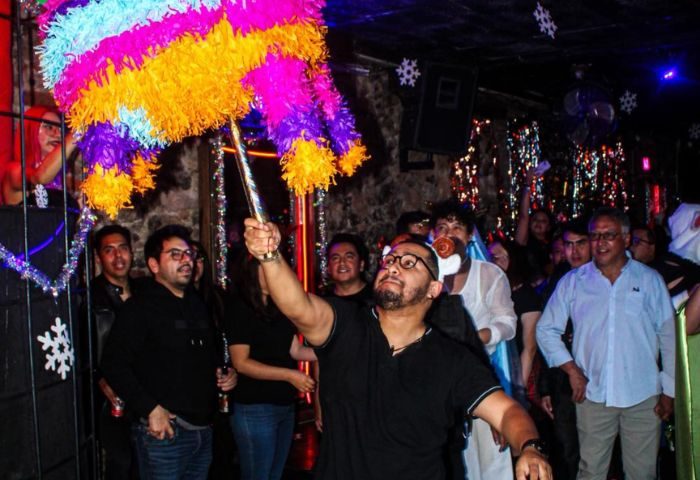 El Pecado Gay Bar in Mexico: A man swings a colorful piñata at a gay bar, surrounded by a crowd of people celebrating.