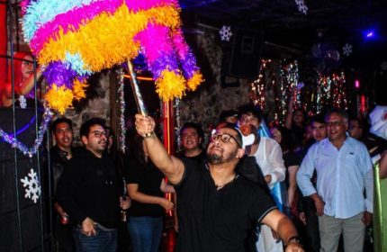 El Pecado Gay Bar in Mexico: A man swings a colorful piñata at a gay bar, surrounded by a crowd of people celebrating.