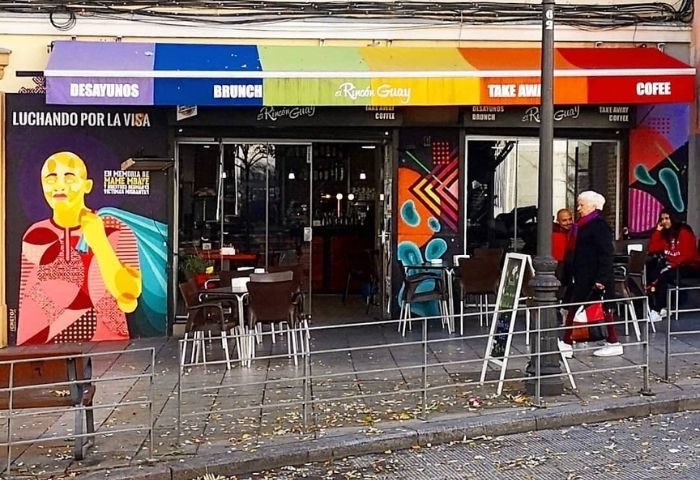 El Rincón Guay, a gay bar in Madrid, Spain. Rainbow awning, mural art, outdoor seating. Gay travel advice, LGBTQ+ friendly. Desayunos, brunch, coffee.