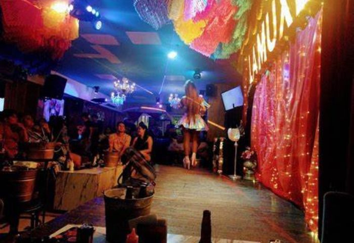 Inside El Secreto de la Muxe gay bar in Puerto Vallarta. A performer is on stage in a festive atmosphere. Gay travel advice.