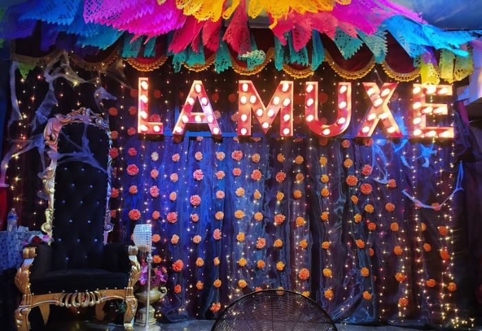 La Muxe gay bar in Puerto Vallarta. Colorful decor, lights, and flowers. A throne sits to the side. Gay travel in Mexico.