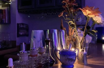 Elixir Mixology Bar in Puerto Vallarta. Gay bar scene with cocktail equipment, flowers, and a sugar bowl. Gay party & drag venue.