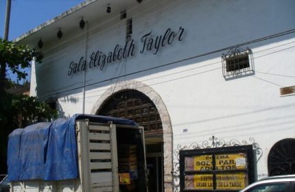 Sala Elizabeth Taylor in Puerto Vallarta, a gay cruising spot. Old theater facade with truck parked in front. Gay travel destination.