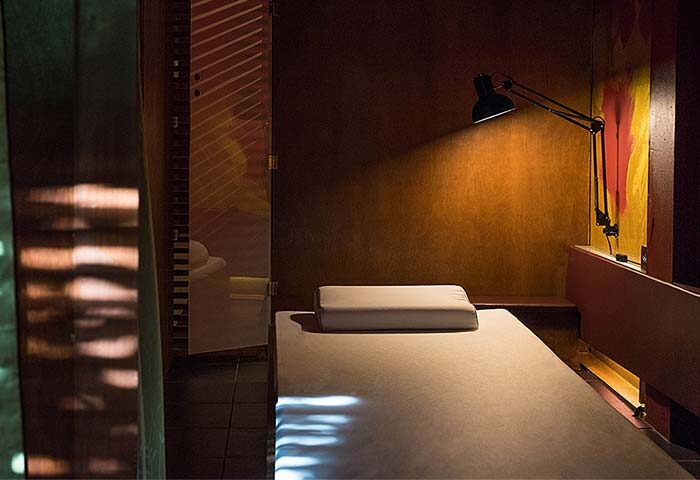 Emerald Green Mens Club, Samui: Interior of a spa room, bed with pillow, and lamp. Gay travel advice for men in Thailand.