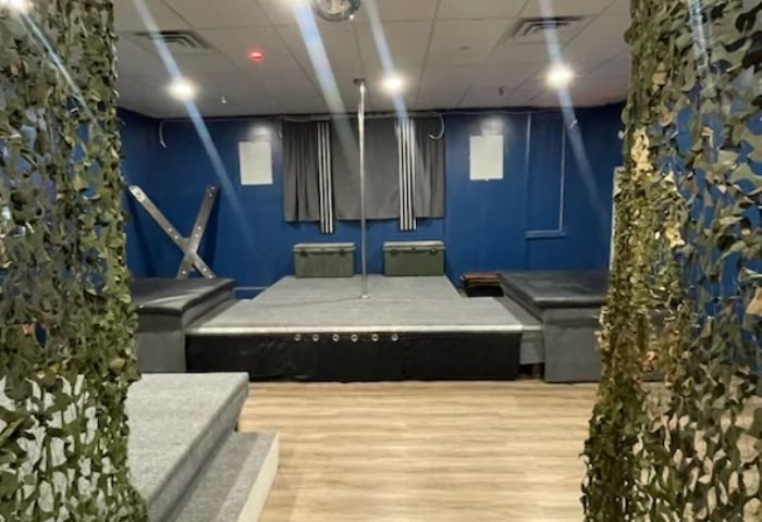 Entourage Las Vegas gay cruising: Interior view with pole, stage, benches, and camouflage netting. Gay travel advice for Las Vegas nightlife.