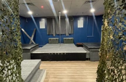 Entourage Las Vegas gay cruising: Interior view with pole, stage, benches, and camouflage netting. Gay travel advice for Las Vegas nightlife.