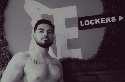 Shirtless man with tattoo at Entourage Las Vegas. Gay cruising spot near lockers. Las Vegas gay travel advice.