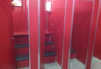 Inside Erotic Palace, a gay cruise club in Barcelona. Red stalls with shelves for intimate encounters. Gay travel advice.