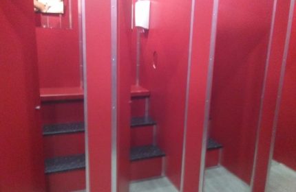 Inside Erotic Palace, a gay cruise club in Barcelona. Red stalls with shelves for intimate encounters. Gay travel advice.