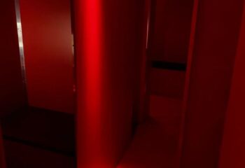 Interior of Erotic Palace, a gay cruise club in Barcelona. Red lighting, dark corners, and suggestive atmosphere for gay men's travel.